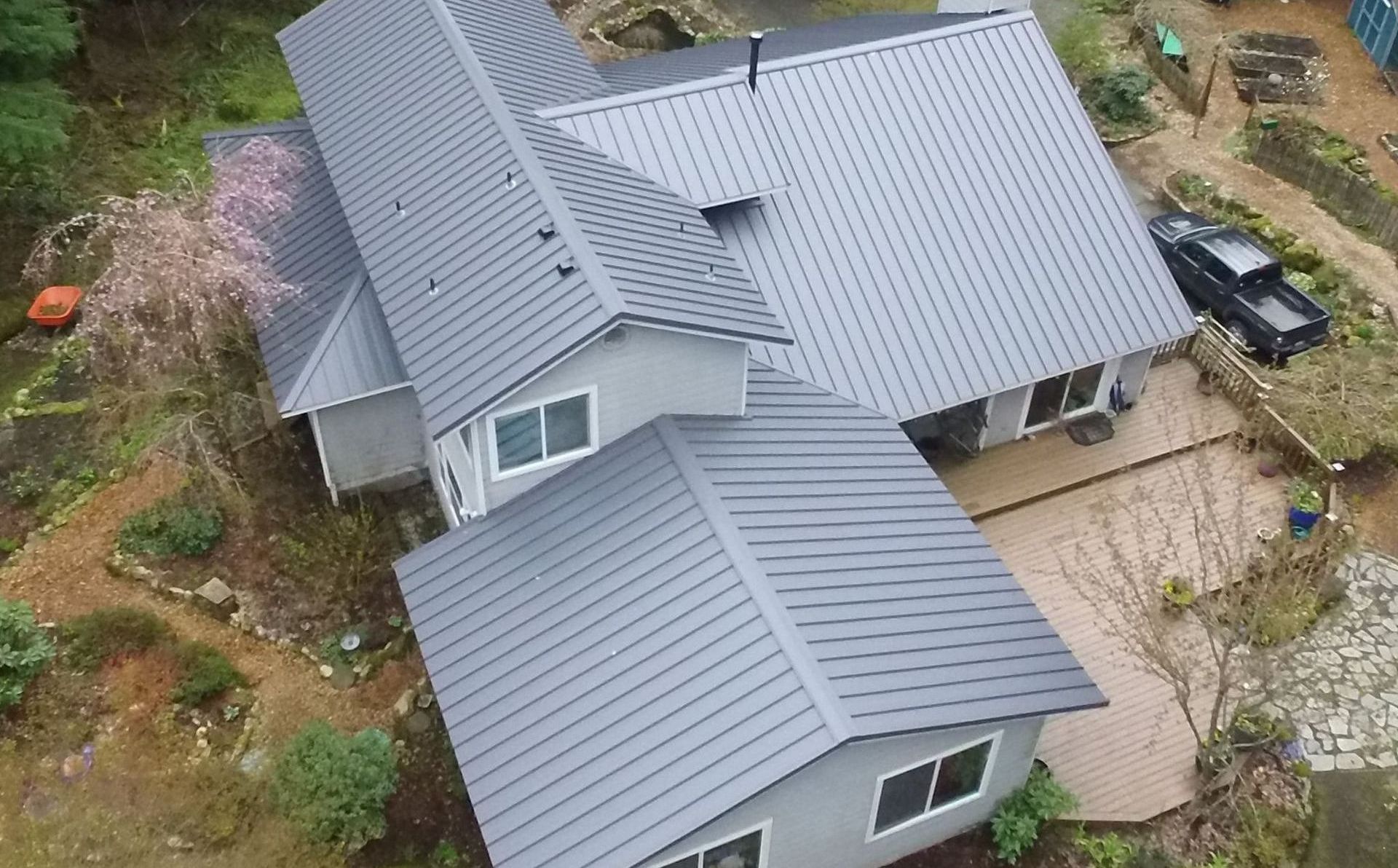 An aerial view of a house with a metal roof from Washington Roofing Services near Arlington WA