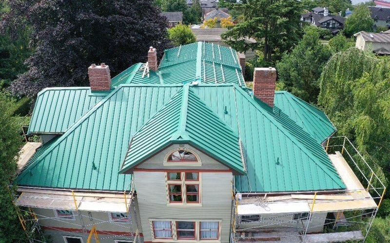 An aerial view of a large house with a green roof from Washington Roofing Services near Arlington WA